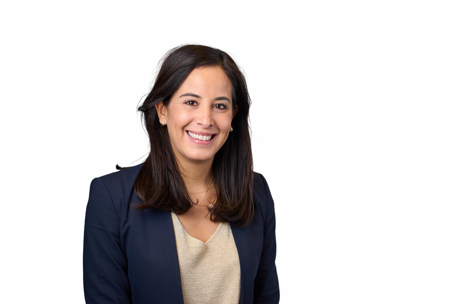A woman smiles, her dark hair framing a light top under a dark blazer, perfectly capturing the essence of professionalism in this corporate headshot by an expert photographer. She stands confidently against a plain white background. James Gifford-Mead Photography - Event Photographer London