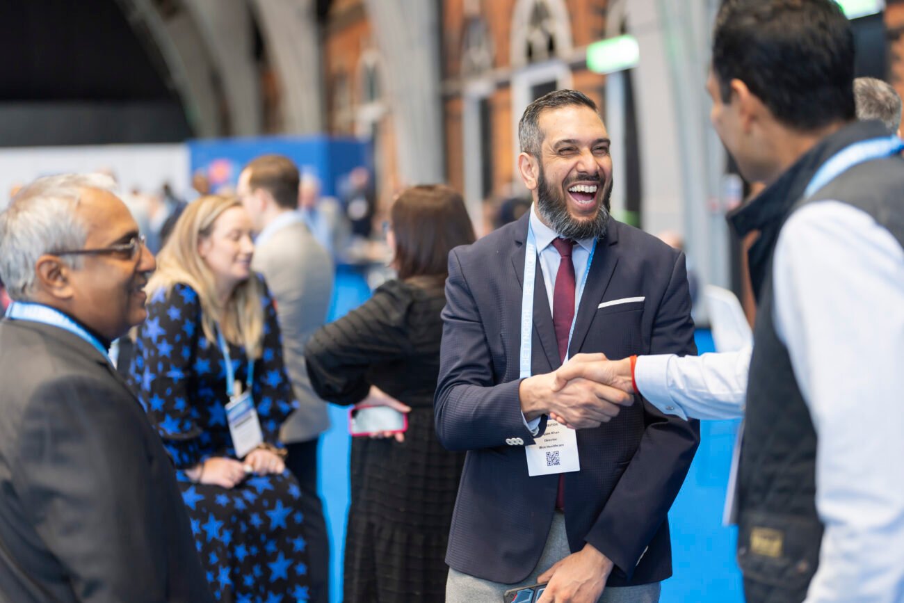 Business professionals networking and shaking hands at event.