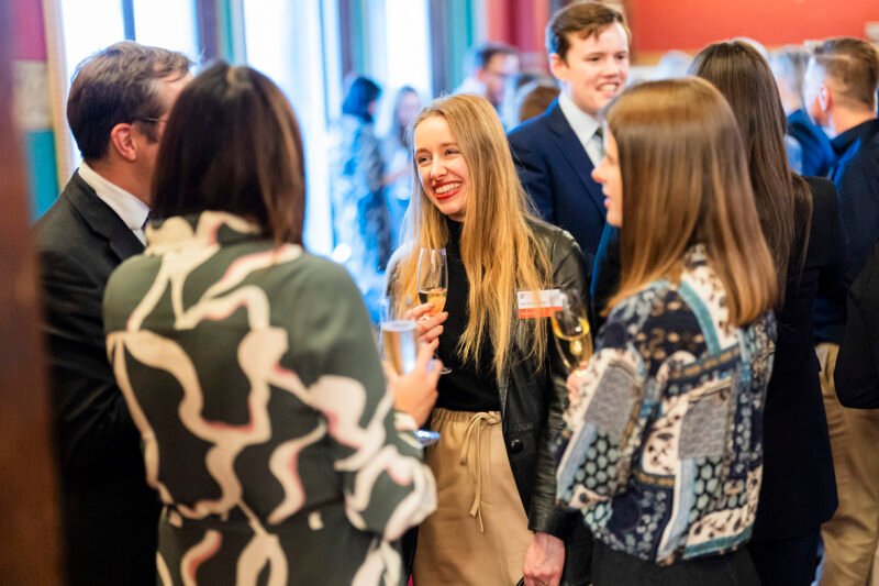 People socialising at a networking event with drinks.
