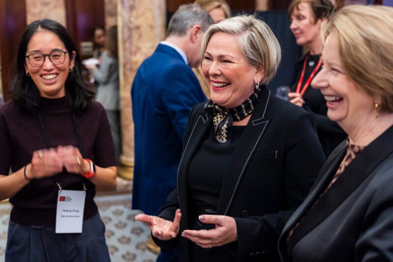 Women smiling and chatting at formal event