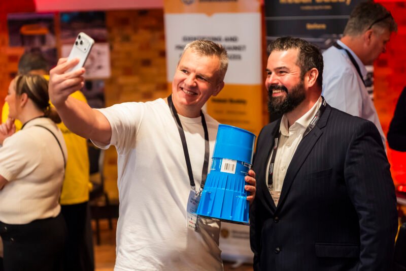 Two men taking a selfie at an event.