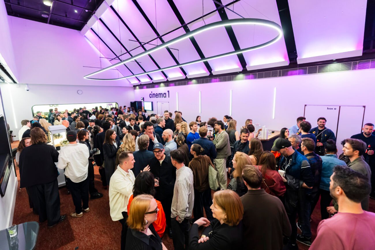 Crowded cinema foyer with people socialising.