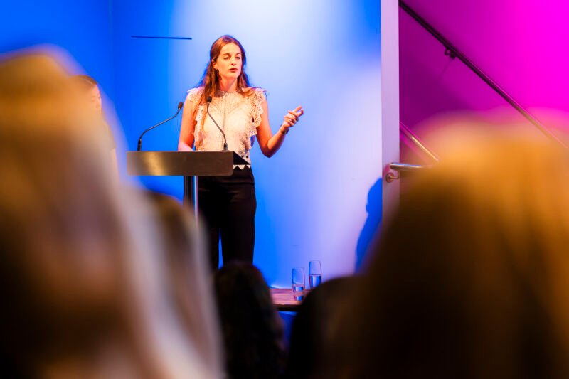 Woman speaking at a conference podium.